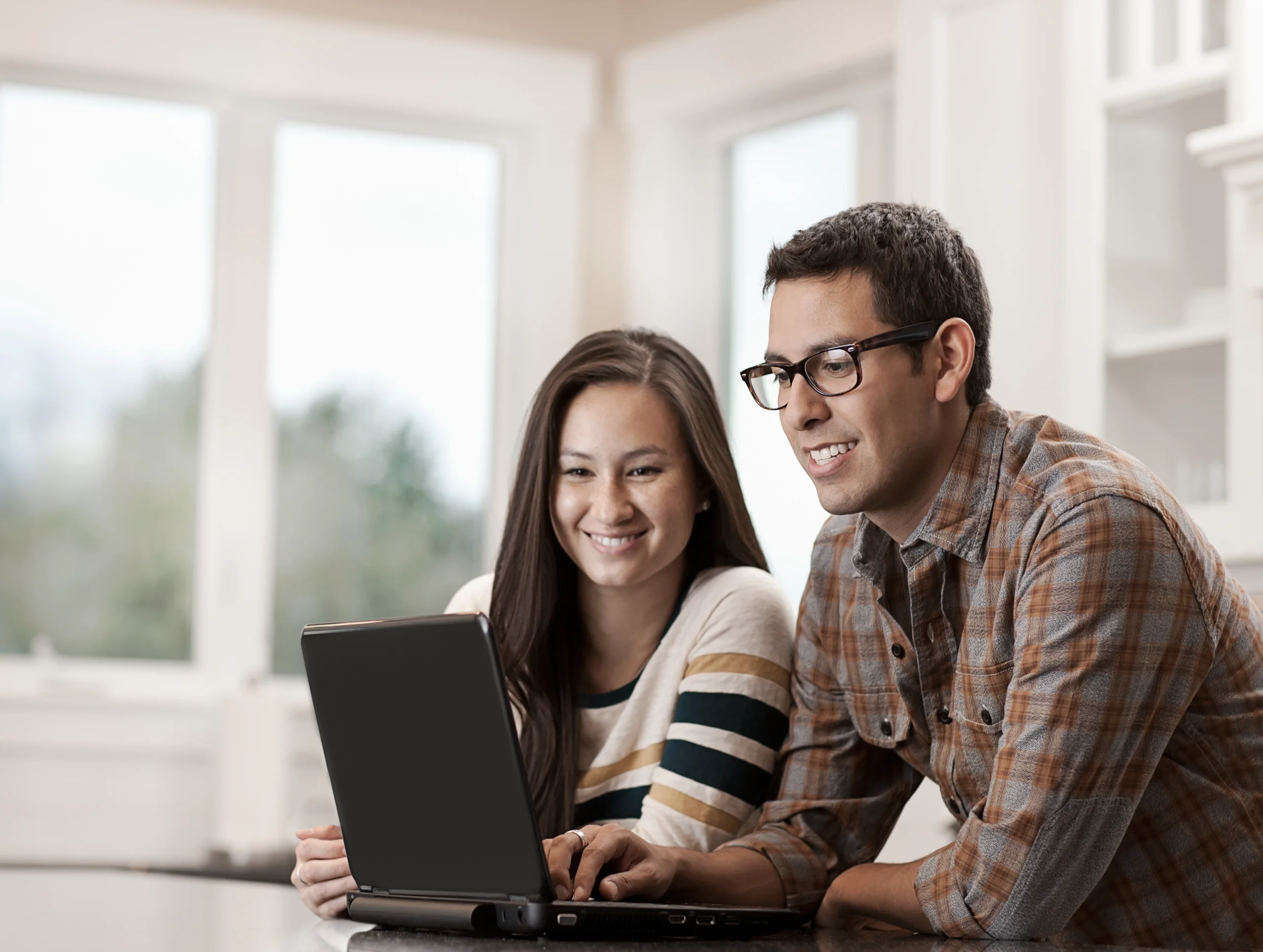 Couple using laptop to access property portfolio app to manage their investments