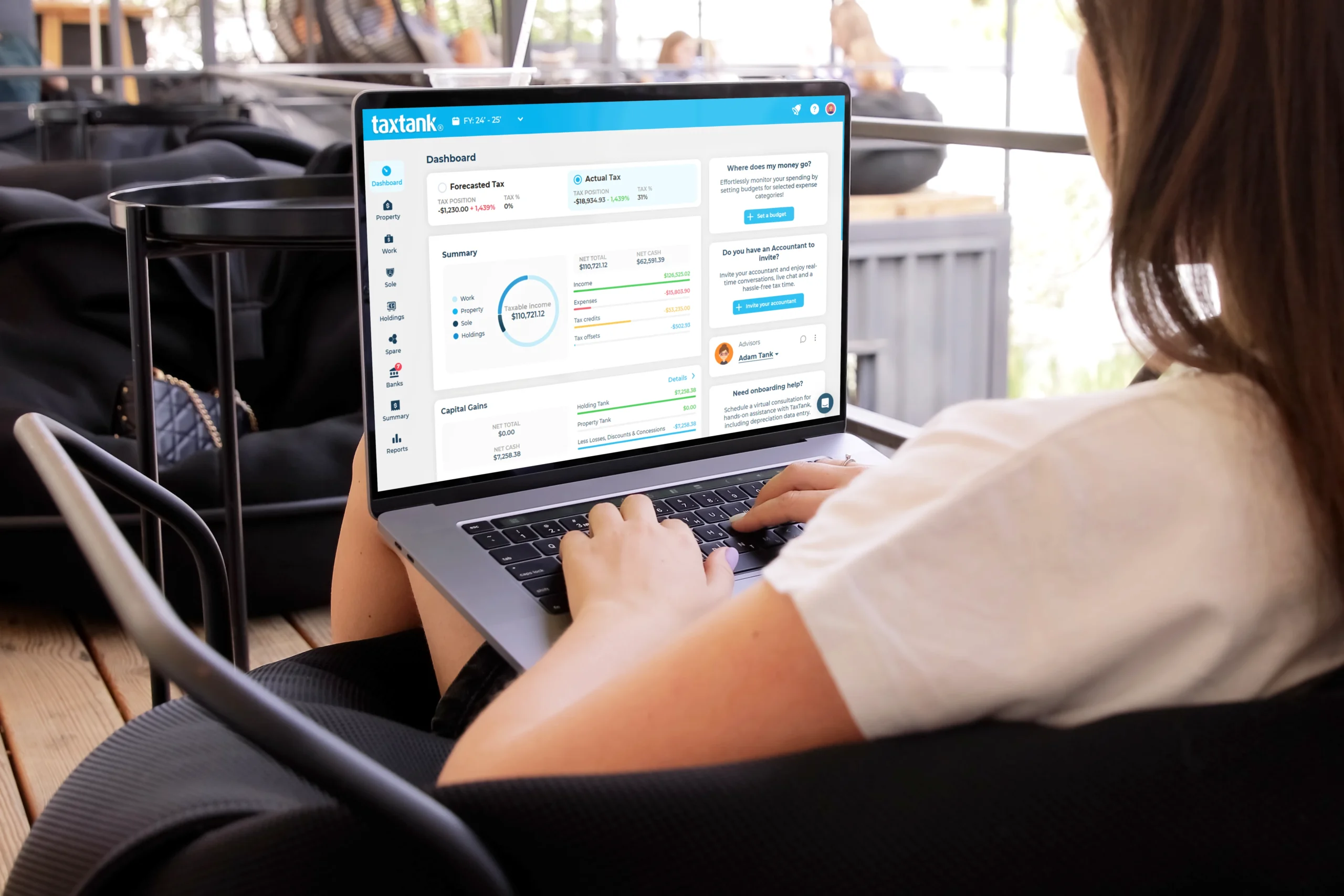 Woman on laptop in coffee shop looking at the best personal accounting software dashboard