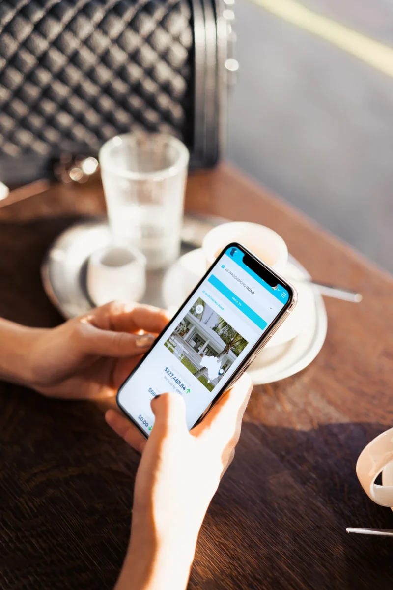 Person at coffee shop on iphone using tax app for investment property