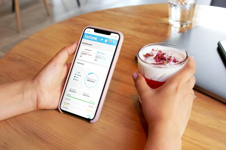 Lady with the best budget app in Australia in hand and drink in the other on pink phone