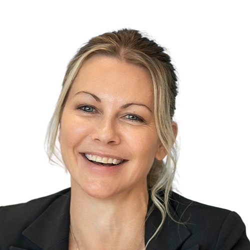 Nicole Kelly, founder of TaxTank has blonde hair in a ponytail and is smiling while wearing a black suit jacket.