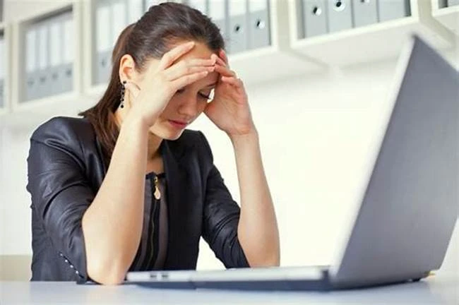 Woman with head in her hands after receiving notice from ATO that they will adjust your tax return