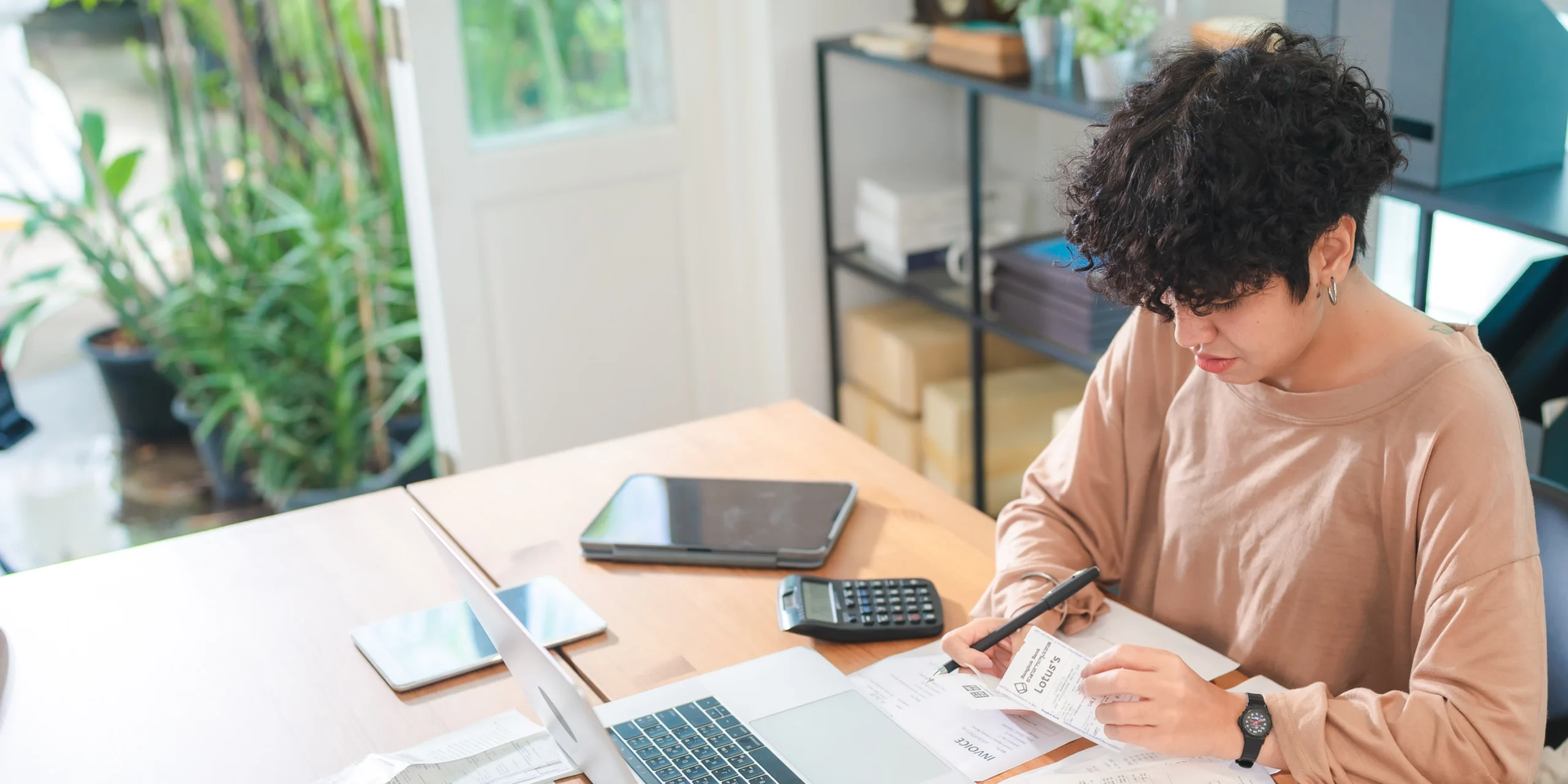 a young woman sitting at her desk organising her working from home tax deductions