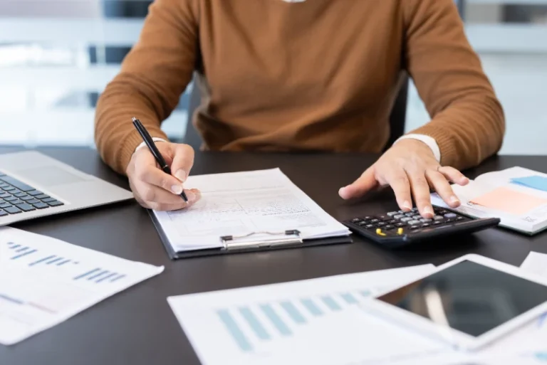 Woman at kitchen table working on paperwork for small business