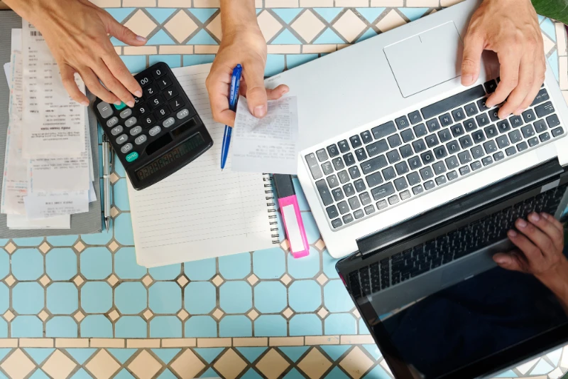 Calculator and laptop on table trying to workout tax receipts