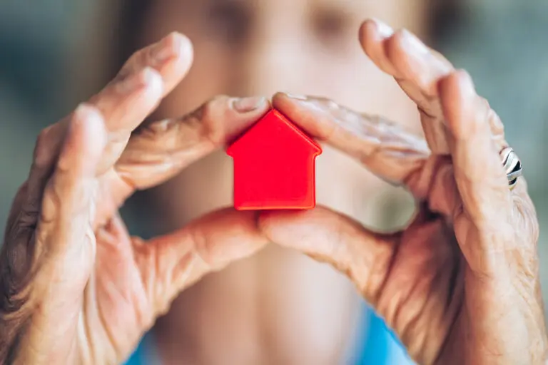 Woman holding a small house toy