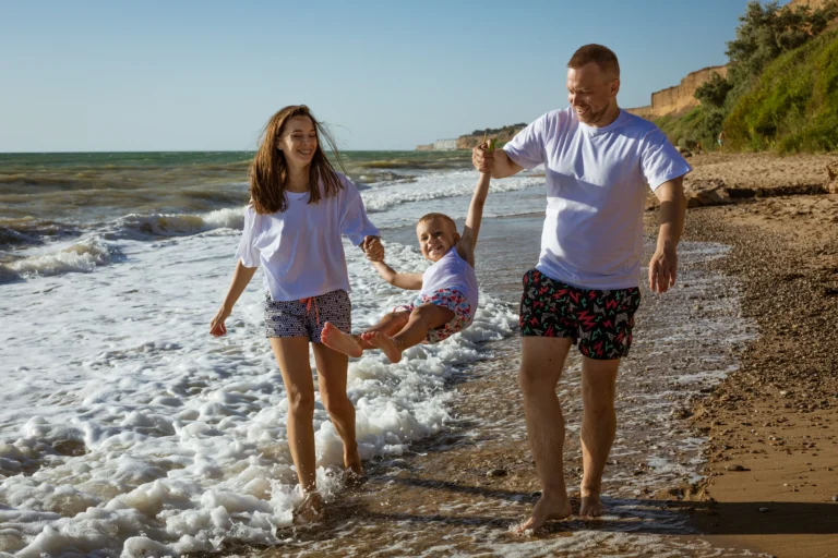 Happy family walking on beach