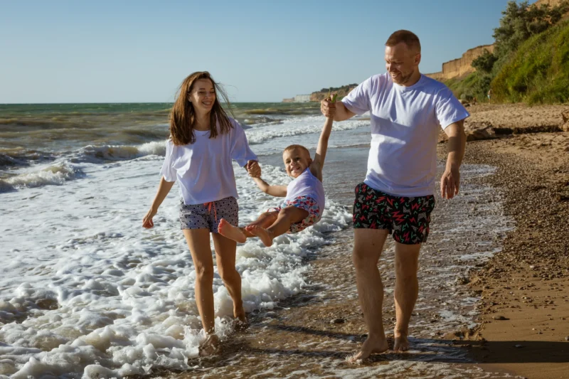 Happy family walking on beach