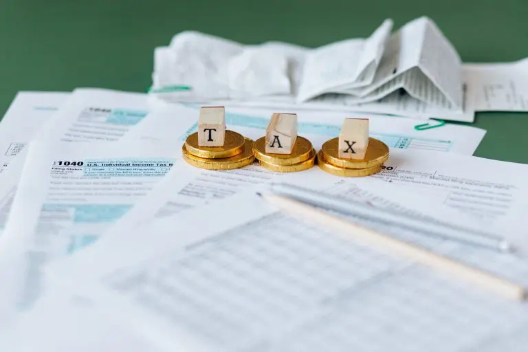 Image of paperwork with tax spelt out on gold coins